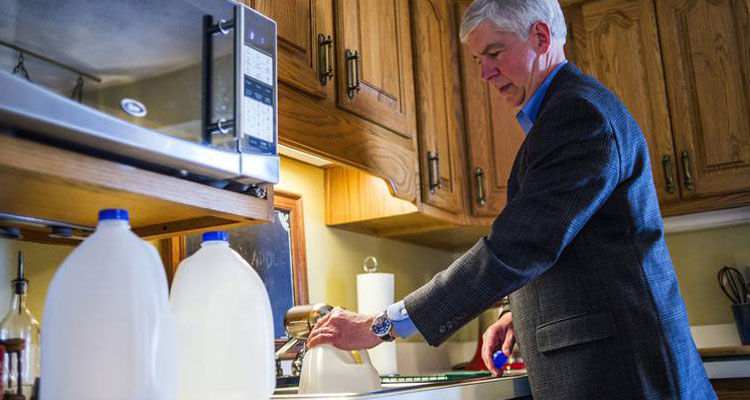 Michigan Gov. Rick Snyder fills jugs with filtered Flint tap water at a home on the city’s east side Monday. Mr. Snyder says he will drink Flint's water for roughly a month to show residents it is safe. PHOTO: JAKE MAY/THE FLINT JOURNAL/ASSOCIATED PRESS 
